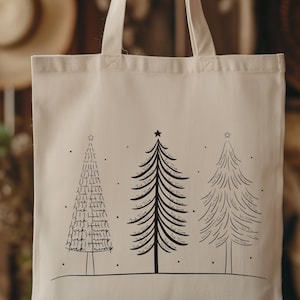 Può includere: Una borsa tote color crema con tre alberi di Natale stilizzati in inchiostro nero. Ogni albero è sormontato da una stella e ha un design unico. La borsa ha due manici ed è realizzata in un tessuto robusto, ideale per la spesa o i regali.