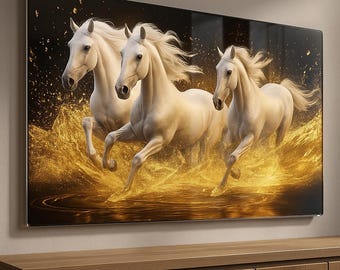 May include: A rectangular wall art piece featuring three white horses galloping through a pool of liquid gold. The background is a deep black, contrasted by bright golden splashes and ripples that surround the horses as they move forward.