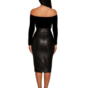 Puede incluir: Un top negro con hombros descubiertos y mangas largas se combina con una falda l&aacute;piz de cuero negro. El vestido es entallado y llega a las rodillas. La modelo lleva tacones altos negros.