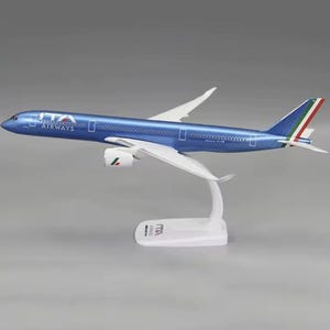 以下が含まれることがあります： 側面には「ITA AIRWAYS」の文字が入った、青と白の模型飛行機。模型は白い翼と白いスタンドが付いています。飛行機の尾翼にはイタリア国旗の色が使われています。