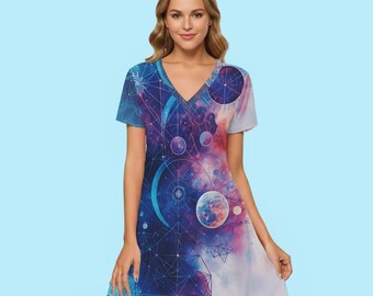 Peut inclure: Robe à col en V avec un motif vibrant sur le thème de l'espace. La robe présente un imprimé galaxie bleu, violet et rose avec des corps célestes et des formes géométriques. La robe à manches courtes a une jupe évasée.