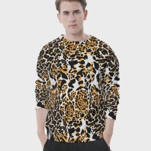 Puede incluir: Una sudadera de cuello redondo con estampado de leopardo en negro, marrón y blanco. La parte superior de manga larga tiene un corte clásico y está hecha de un material suave. El diseño de estampado animal es llamativo.