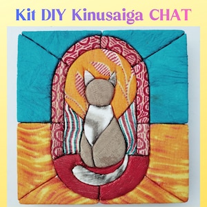 Peut inclure: Un projet de bricolage Kinusaiga représentant une silhouette de chat en tissu dans des tons beige et blanc. Le chat est centré dans un cadre arqué en tissu rouge à motifs, sur un fond composé de blocs de tissu turquoise et orange.