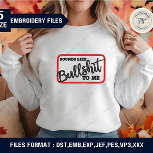 May include: White sweatshirt with the phrase "SOUNDS LIKE BULLSHIT TO ME" in a black and red design. The sweatshirt is part of a set of embroidery files, available in five sizes.