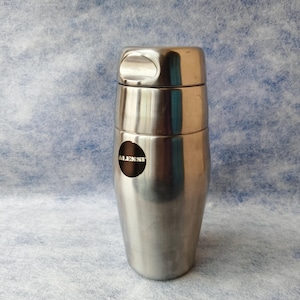 May include: A set of three ceramic mugs with a speckled, matte finish. The mugs are in shades of cream, light gray, and dark gray. Each mug has a simple, minimalist design and a rounded handle.