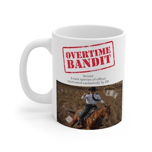 Puede incluir: Taza de cerámica blanca con asa. La taza tiene un sello rojo que dice "OVERTIME BANDIT" y una definición debajo. La taza muestra una imagen de una persona a caballo, con dinero volando.