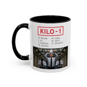 Puede incluir: Taza de cerámica blanca con asa e interior negros. La taza presenta el texto "KILO-1" en un rectángulo rojo, junto con una lista de palabras. Debajo, una foto de tres personas uniformadas.