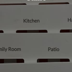May include: A white game with the text "Stop the Light Switch Guessing Game" at the top. The game has labeled sections for "Kitchen", "Family Room", and "Patio". The bottom reads "Spring cleaning is for clarity. Why is your hallway still a mystery?"