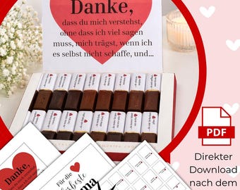 May include: A gift box of assorted chocolates with individual wrappers. The box is open, revealing rows of chocolate bars. A large red heart with German text is above the chocolates. Additional cards and a PDF icon are also visible.