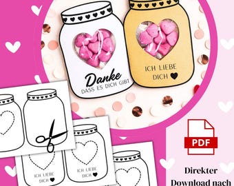 May include: Two jar-shaped cards, one white and one tan, each with a heart-shaped window filled with pink heart candies. The white card says "Danke" and "DASS ES DICH GIBT". The tan card says "ICH LIEBE DICH".