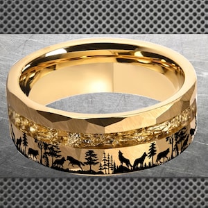 May include: A gold ring with a faceted outer band and a detailed inner band. The inner band features a black silhouette of a forest scene with wolves howling and trees. The ring is a piece of jewellery.