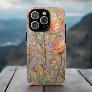 May include: A smartphone case featuring an iridescent, stained-glass style floral pattern with gold-toned outlines. The design displays multi-colored petals in shades of peach, pink, and green with a shimmering, reflective finish and a triple camera lens.
