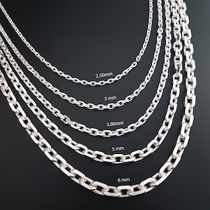 May include: Five silver-toned metal chain necklaces arranged in a cascading pattern, each featuring distinct link widths labeled as 2.50mm, 3 mm, 3.80mm, 5 mm, and 6 mm. The chains have a polished finish and a classic oval link design.
