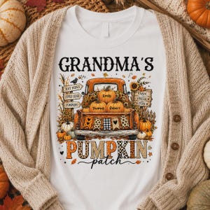 May include: A white t-shirt featuring a graphic of an orange pickup truck filled with pumpkins. The text reads GRANDMA'S PUMPKIN PATCH, with names Emily, Thomas, and Robert on the pumpkins. The design includes sunflowers, leaves, and signs.