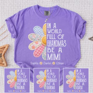 May include: A lilac-colored t-shirt features a daisy design with pastel-colored petals and the text "IN A WORLD FULL OF GRANDMAS BE A MIMI". The names Sophia, Daniel, and Ethan are printed below the text.