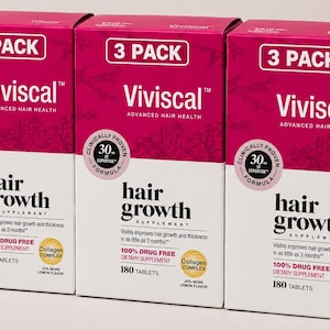 Könnte beinhalten: Drei identische rechteckige Schachteln des Nahrungsergänzungsmittels Viviscal Advanced Hair Health. Jede magenta-weiße Schachtel zeigt den Text 3 PACK, Viviscal, hair growth supplement, 180 tablets, 100% drug free und einen gelben Collagen Complex Kreis.