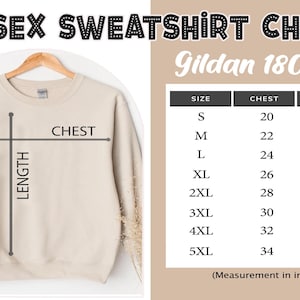 Może przedstawiać: Beżowa bluza unisex wisi na drewnianym wieszaku. Obraz zawiera tabelę rozmiar&oacute;w dla bluzy Gildan 18000 z wymiarami klatki piersiowej i długości w calach dla rozmiar&oacute;w od S do 5XL. U g&oacute;ry znajduje się napis "UNISEX SWEATSHIRT CHART".