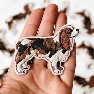 May include: A set of three ceramic mugs with a speckled, matte finish. The mugs are in shades of cream, light gray, and dark gray. Each mug has a simple, modern design and a rounded handle.