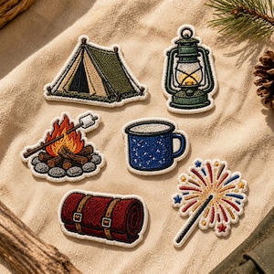 May include: Six embroidered patches featuring camping themes: a green tent, a green lantern, a campfire with a marshmallow on a stick, a blue speckled mug, a rolled red sleeping bag, and a colorful firework sparkler on a light fabric background.