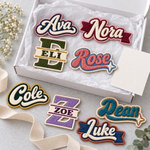 May include: A collection of embroidered name patches in various colors and fonts, including names like Ava, Nora, Eli, Rose, Cole, Zoe, Dean, and Luke. Some patches feature script lettering, while others incorporate block letters or banner designs.