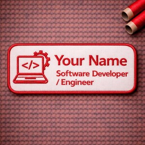 May include: A white rectangular patch with a red border, embroidered with the text "Your Name" in red, and "Software Developer / Engineer." A red laptop icon and gear are on the left. Two spools of red thread are in the background.