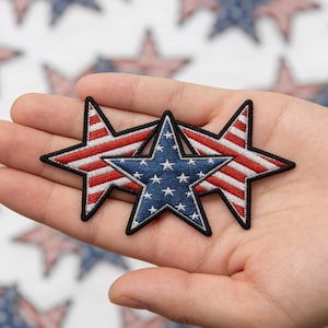 May include: Three star-shaped patches with patriotic designs. One star features a blue field with white stars, while the other two have red and white stripes. Each patch has a black border.
