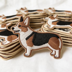 May include: A white ceramic mug with a black handle and the text "But First, Coffee" in a black, bold font. The mug is sitting on a wooden surface. The mug is approximately 4 inches tall.