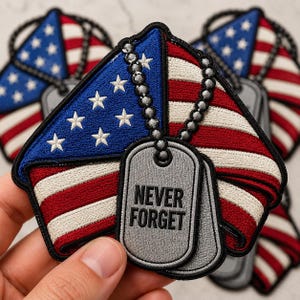 May include: Embroidered patch featuring a stylized American flag design with red and white stripes and a blue corner with white stars. Includes two gray dog tags with the text "NEVER FORGET".