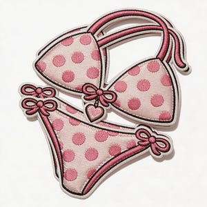 May include: Embroidered patch of a pink polka dot bikini set. The bikini top has straps and a bow, and the bottoms have bows on each side. A heart charm hangs from the top. The edges are outlined in black.