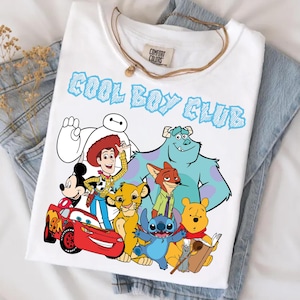 Może przedstawiać: Biały t-shirt z kr&oacute;tkim rękawem z napisem COOL BOY CLUB niebieskimi literami. Grafika przedstawia r&oacute;żne postacie animowane: Baymaxa, Chudego, Myszkę Miki, Zygzaka McQueena, Simbę, Nicka Bajera, Sulleya, Sticha, Kubusia Puchatka i Remy'ego.