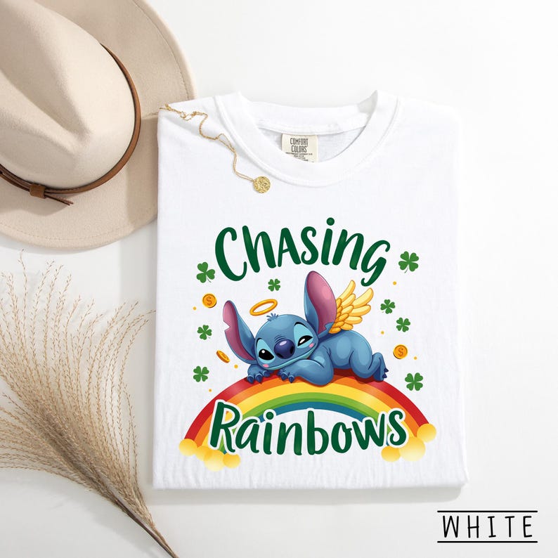 May include: White t-shirt with a cartoon character on a rainbow, with the words "Chasing Rainbows". The design includes shamrocks and gold coins. The word "WHITE" is at the bottom. The t-shirt is a Comfort Colors brand.