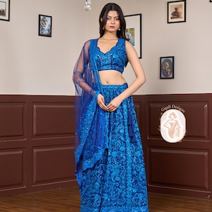 May include: A vibrant blue, sleeveless, embroidered lehenga choli set. The set includes a matching dupatta. The intricate embroidery covers the entire skirt and top, creating a cohesive and elegant look. The outfit is suitable for special occasions.