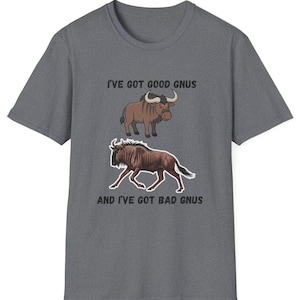 May include: Gray t-shirt with the text "I'VE GOT GOOD GNUS" above a cartoon illustration of a brown wildebeest and "AND I'VE GOT BAD GNUS" below a running wildebeest illustration. The shirt is made of a soft material.