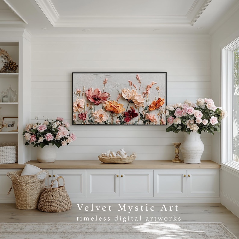 May include: A floral artwork with a black frame, featuring textured flowers in shades of pink, orange, and red. The artwork hangs above a white cabinet with a vase of pink roses. The text "Velvet Mystic Art" is displayed below.