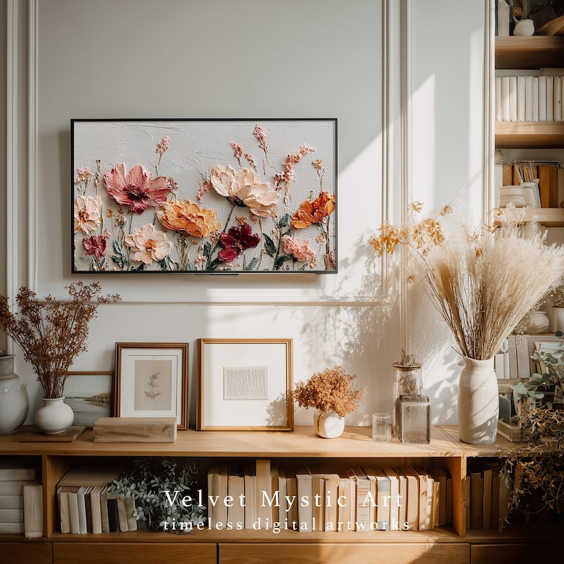 May include: A framed floral artwork with textured, raised paint in shades of pink, peach, and burgundy. The artwork hangs above a wooden shelf with framed art, vases, and books. The text "Velvet Mystic Art" and "timeless digital artworks" is at the bottom.