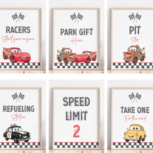 May include: Six framed prints with a racing theme. Each print features a cartoon car and text such as "Racers, Start your engine", "Park Gift Here", "Pit Stop", "Refueling Station", "Speed Limit 2", and "Take One For the road".