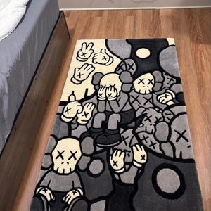 Hand tufted KAWS inspired area rug featuring cartoon skull characters with X eyes in black, gray and cream colors. Handmade street art rug designed for modern bedrooms, gaming rooms, hypebeast interiors and contemporary home decor. Soft plush tufted carpet with urban art aesthetic, luxury floor mat for living room, dorm room, studio apartment and creative spaces. Unique graphic rug with designer inspired artwork, custom handmade statement piece for collectors, sneaker room decor