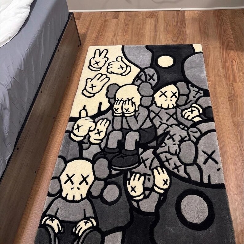Hand tufted KAWS inspired area rug featuring cartoon skull characters with X eyes in black, gray and cream colors. Handmade street art rug designed for modern bedrooms, gaming rooms, hypebeast interiors and contemporary home decor. Soft plush tufted carpet with urban art aesthetic, luxury floor mat for living room, dorm room, studio apartment and creative spaces. Unique graphic rug with designer inspired artwork, custom handmade statement piece for collectors, sneaker room decor