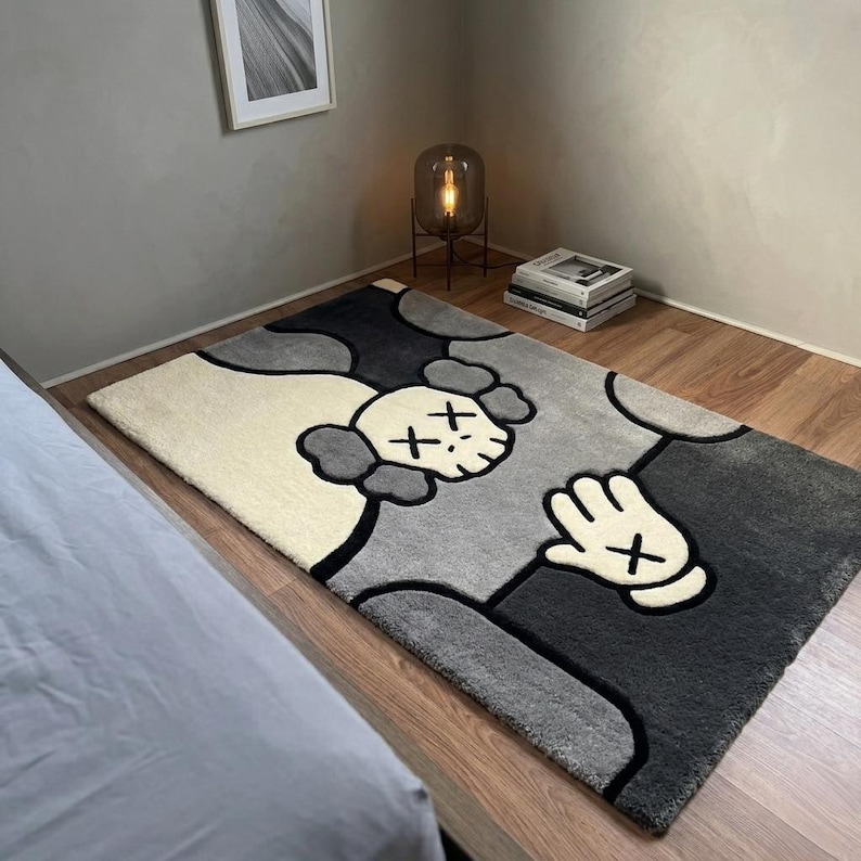 Modern tufted area rug with skull and glove graphic design in black, gray, and ivory tones. Handmade streetwear-inspired carpet ideal for bedrooms, gaming setups, and contemporary home decor."