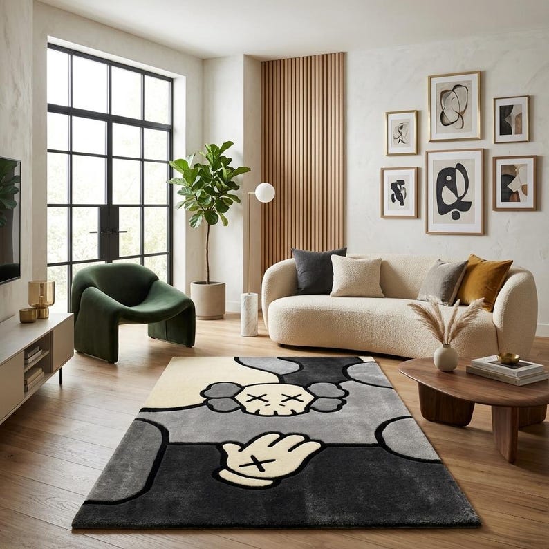 K&ouml;nnte beinhalten: Ein rechteckiger Teppich mit einem stilisierten Grafikdesign, das einen Totenkopf und eine Hand mit X-f&ouml;rmigen Augen in einer Farbpalette aus Creme, Hellgrau, Dunkelgrau und Schwarz zeigt. Der Teppich hat eine weiche Textur und kr&auml;ftige Konturen.