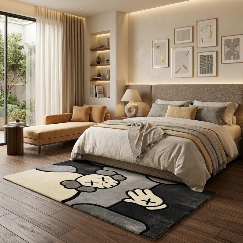 K&ouml;nnte beinhalten: Ein rechteckiger Teppich mit einem stilisierten Cartoon-Charakter-Design, das einen cremefarbenen Kopf, schwarze Umrisse und eine markante Hand mit vier Fingern zeigt. Der Teppich verwendet eine Farbpalette aus Creme, Hellgrau und Anthrazit.