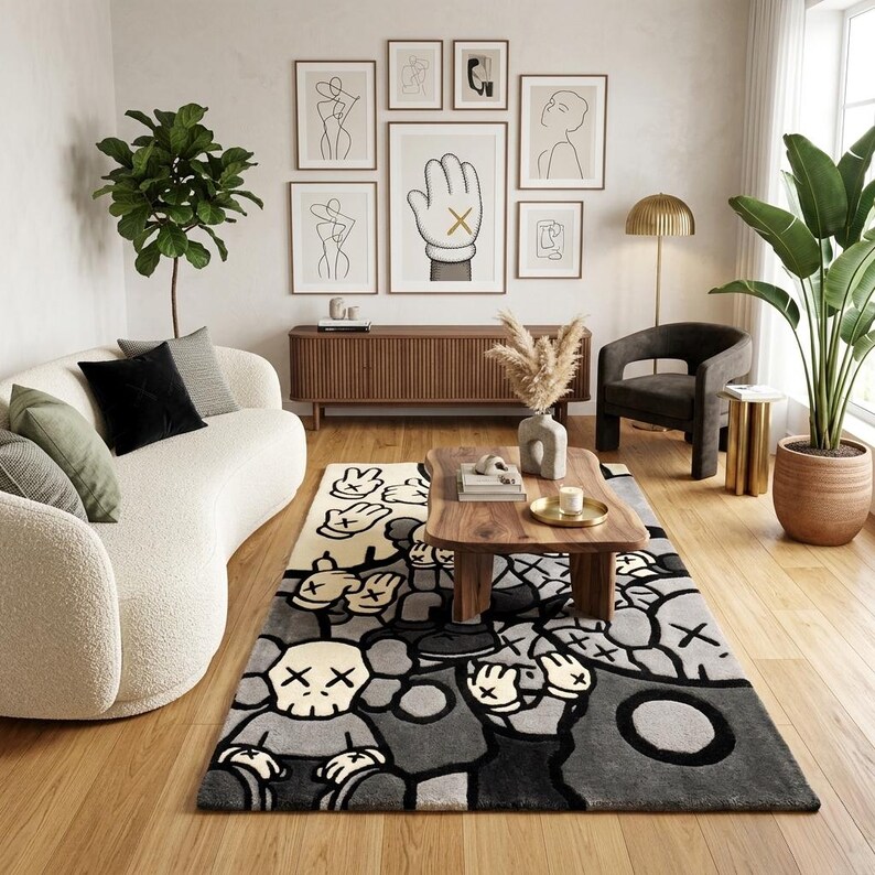 May include: A rectangular area rug featuring a graphic pattern of cartoon-style characters with skull heads and gloved hands in shades of gray, black, and cream. The design includes repeated motifs of hands with X-shaped eyes and fingers held up.