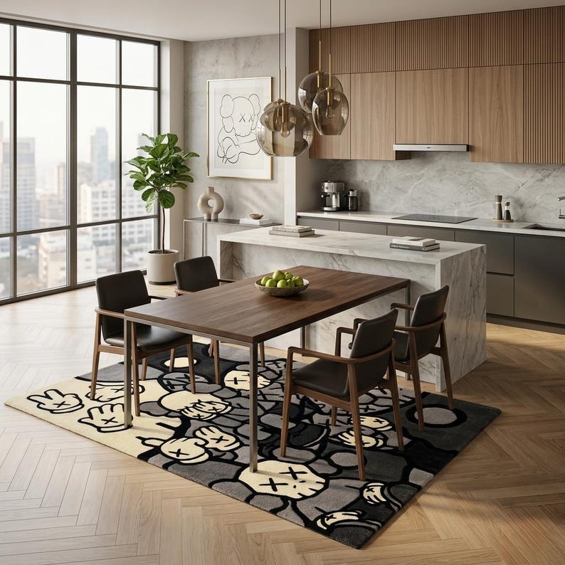 May include: A rectangular area rug featuring a repeating graphic pattern of cartoon-style gloved hands and skull-like faces in shades of cream, gray, and black, positioned beneath a wooden dining table with four dark chairs in a modern kitchen.