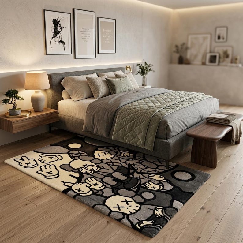 May include: A rectangular area rug featuring a repeating graphic pattern of cartoon-style characters with X-shaped eyes and gloved hands. The design uses a color palette of cream, light gray, dark gray, and black, covering the entire surface.