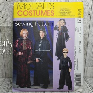 May include: McCall's Costumes sewing pattern M4621 for a hooded cloak and a long-sleeved dress. The pattern includes instructions for sizes medium, large, and extra large.