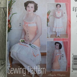 May include: A sewing pattern for a vintage-style dress with a lace trim. The pattern is for sizes 6-8-10-12-14 and is called "A5". The pattern includes instructions for making a dress with a fitted bodice and a full skirt.