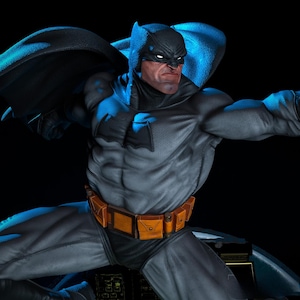 May include: A detailed statue of Batman in a dynamic pose, featuring a gray and black suit with a yellow utility belt. The figure has a stern expression and is set against a dark background, with blue lighting highlighting the cape and cowl.