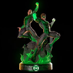 May include: A statue of two Green Lantern figures in dynamic poses, clad in black and green suits. The base features the Green Lantern symbol, with glowing green accents and a black background. The statue is a collectible item.