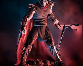 Puede incluir: Una figura detallada de Shredder de las Tortugas Ninja. La figura está en una pose dinámica, con un casco, armadura y una capa roja. Sostiene una katana y tiene armas con forma de garra en las manos. La figura se encuentra sobre una base rocosa.