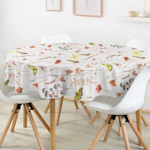 Peut inclure: Une nappe ronde à fond blanc ornée d'un motif répétitif de papillons jaunes, de fleurs orange et de tiges botaniques brunes. Le tissu recouvre une table circulaire et présente un imprimé inspiré de la nature avec des tiges délicates.